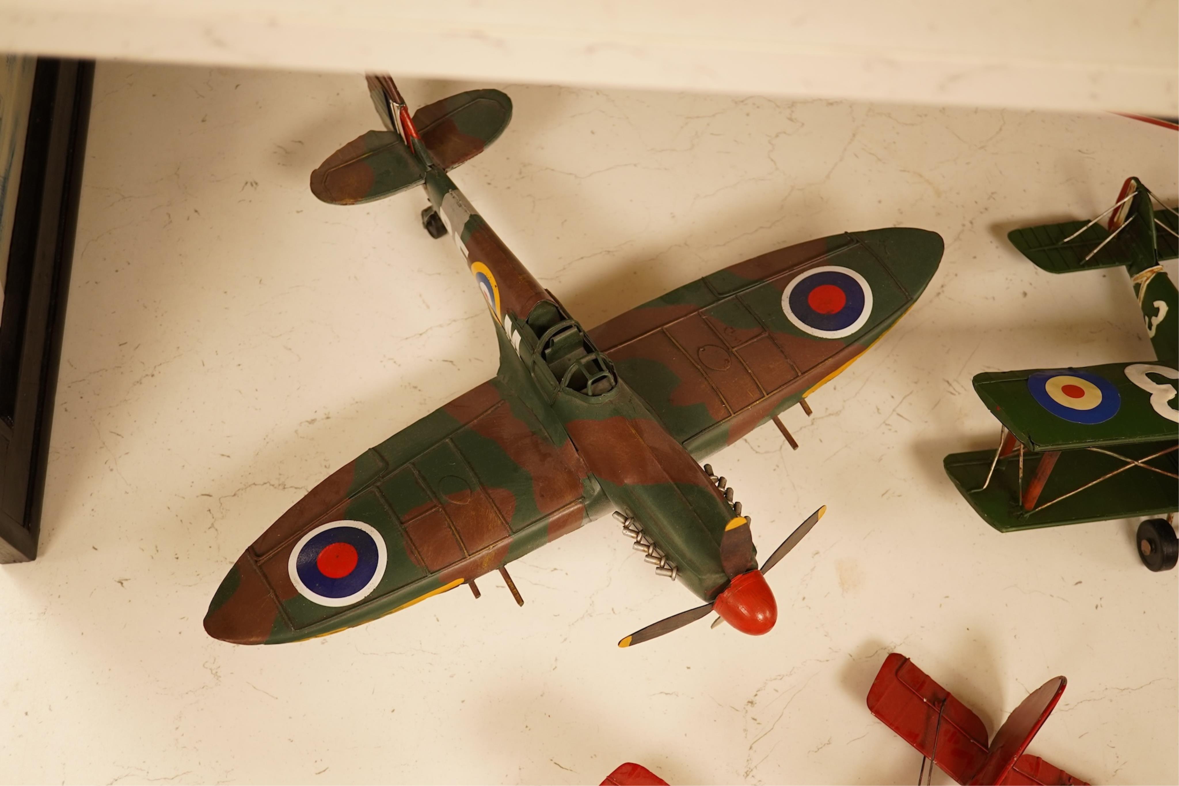 Five decorative metal models of military aircraft, including two Supermarine Spitfires, two First World War, British bi-planes, a German Albatros D.III bi-plane, and a wooden model of RMS Queen Mary, hull 77cm long